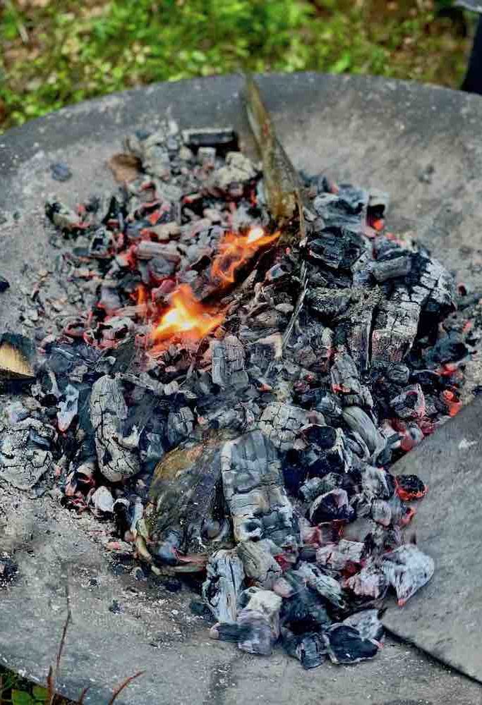 Mye av maten lages på åpen ild på kjøkkenet som ligger ute i skogen.